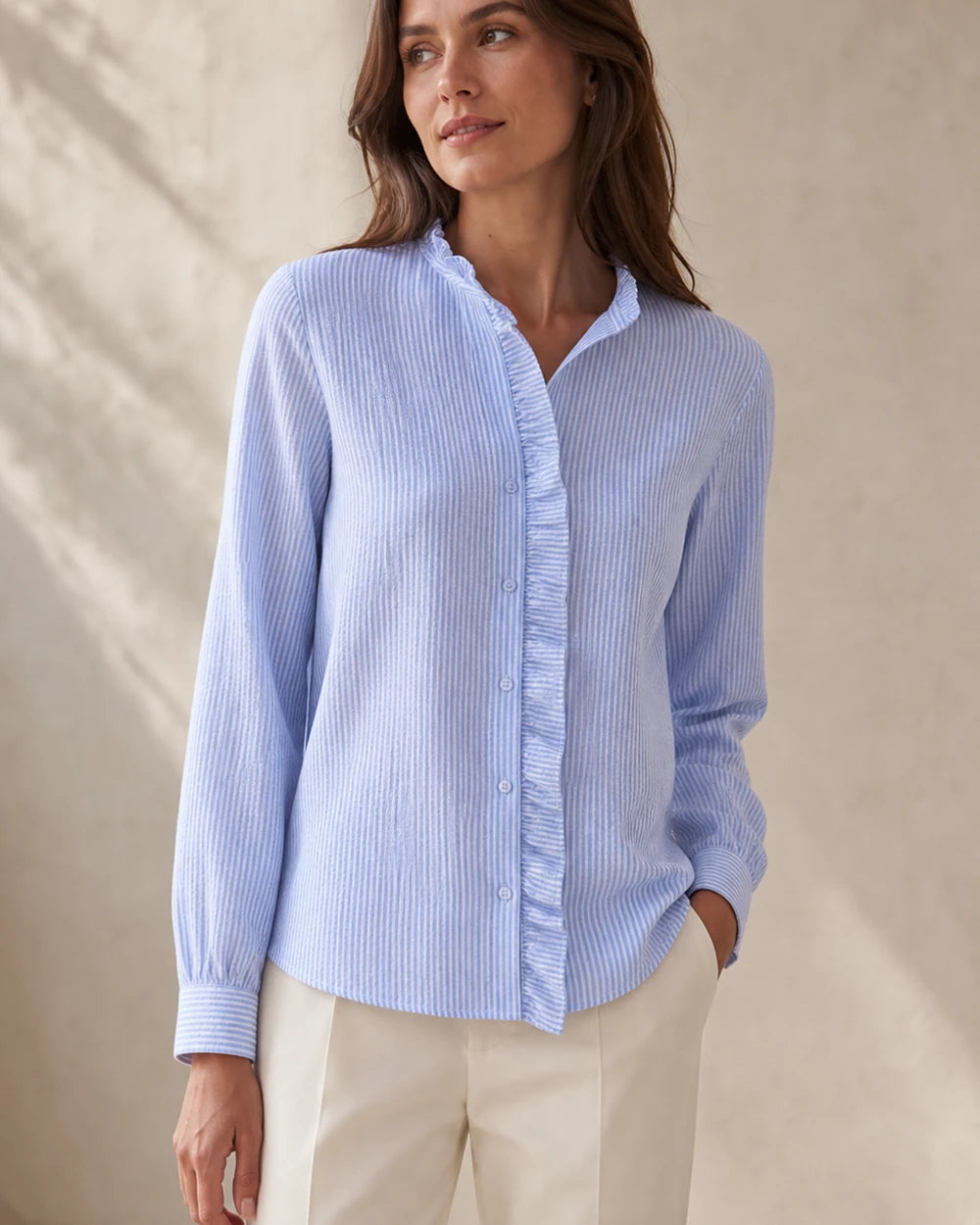 Women's light blue ruffle-trim blouse, front product view.