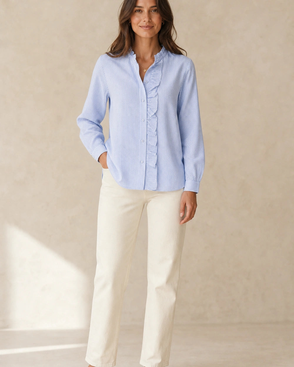 Women's light blue ruffle-trim blouse, complete styled silhouette.