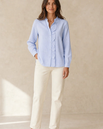 Women's light blue ruffle-trim blouse, complete styled silhouette.