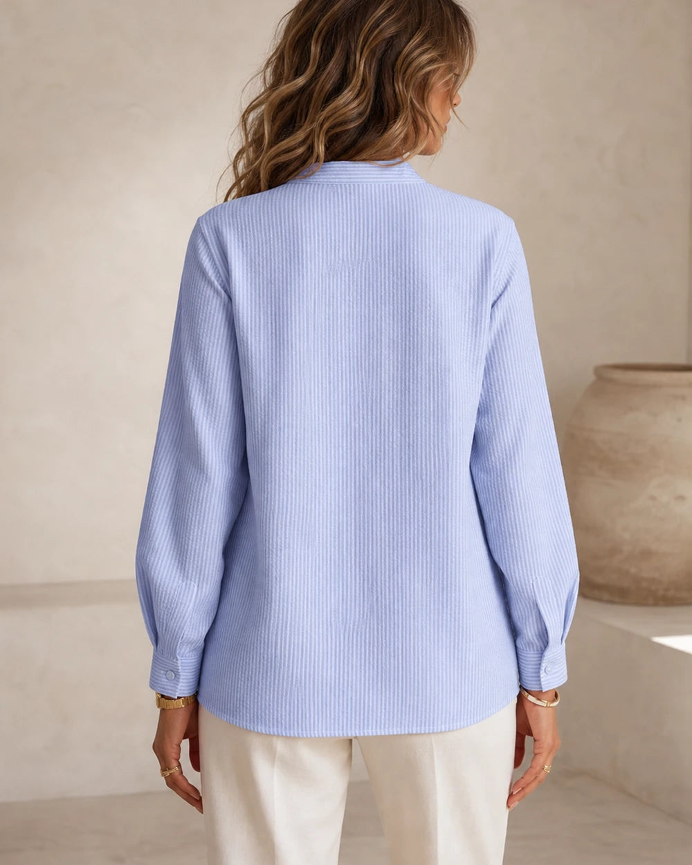 Women's light blue ruffle-trim blouse, rear fit view.
