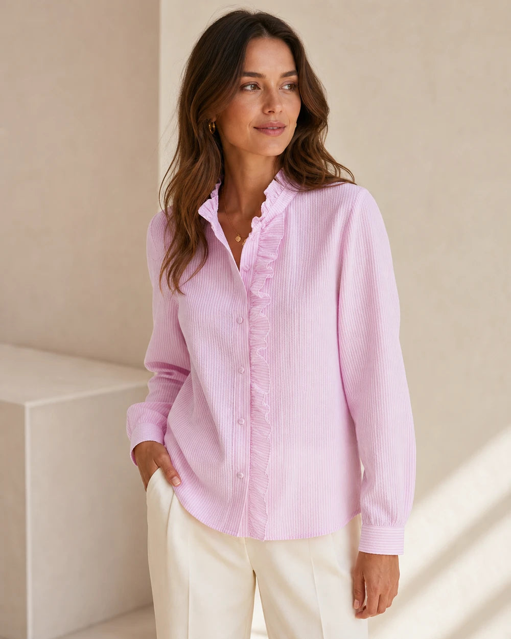 Women's pink ruffle-trim blouse, front product view.