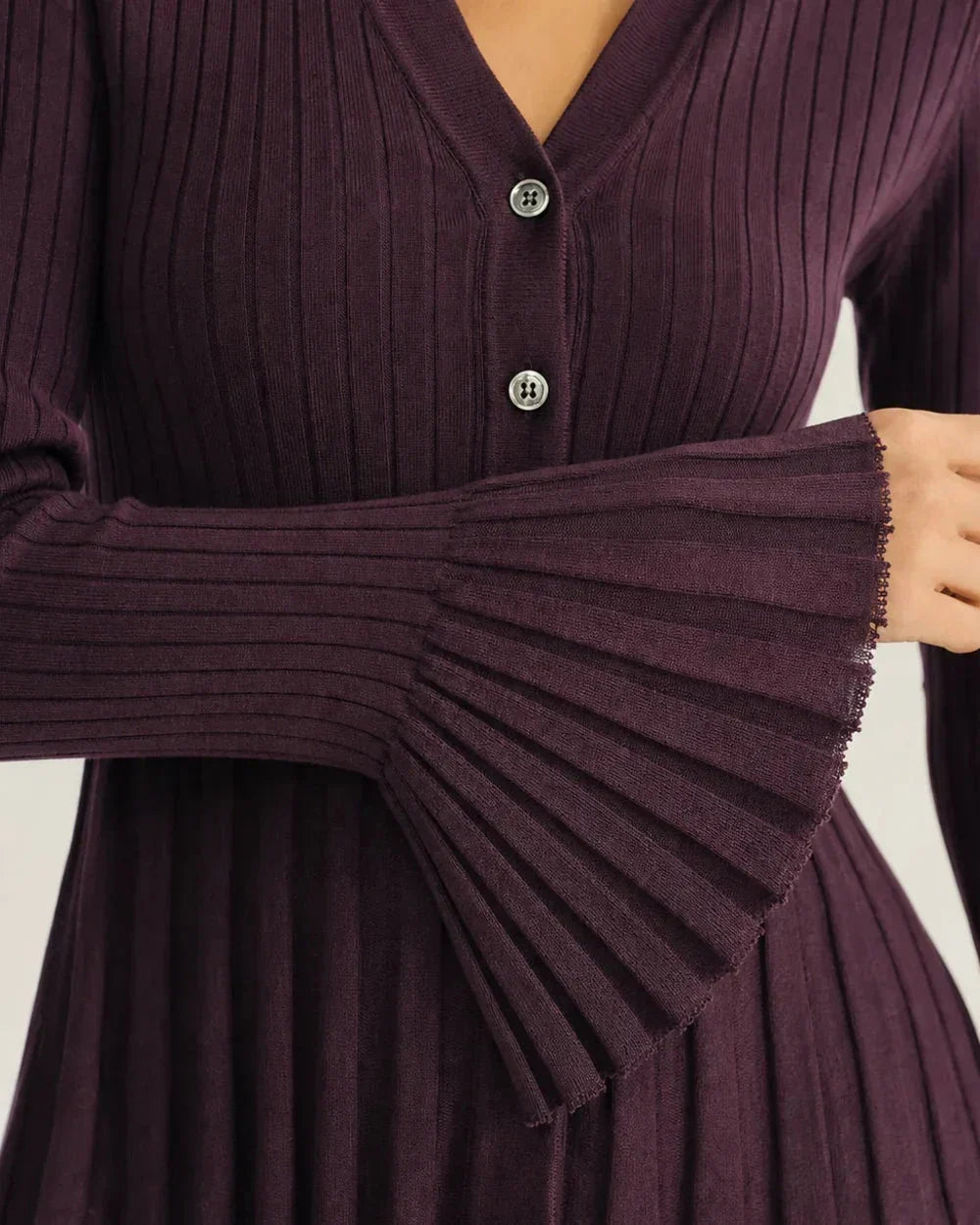 Close-up of the purple rib knit, buttons and flared cuff.