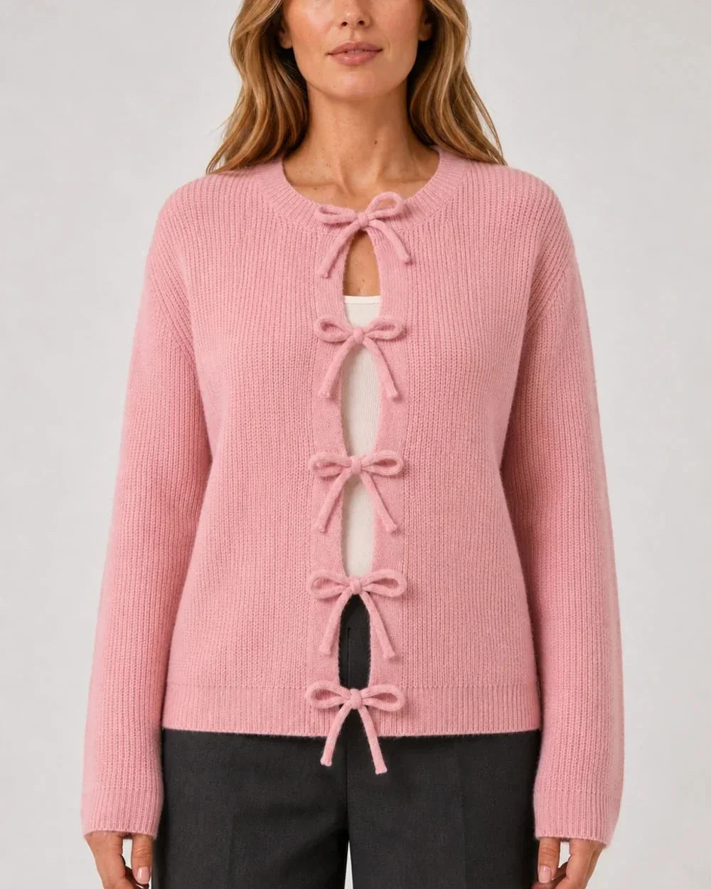 Pink ribbed cardigan with tonal bow ties, straight front fit.
