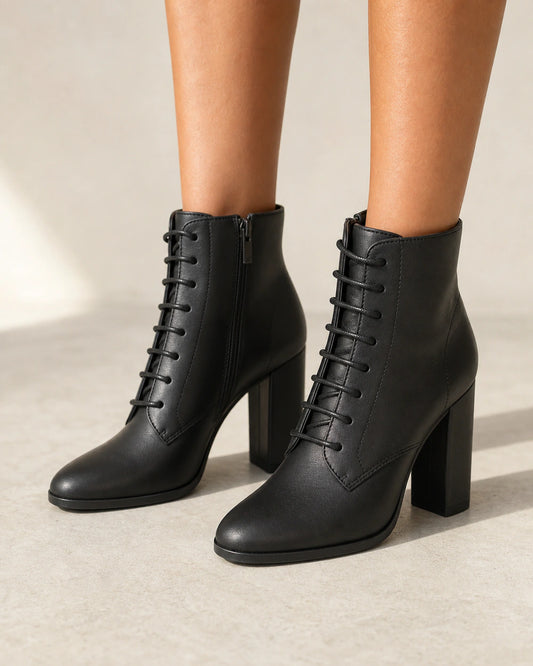 Women's black lace-up high-heel ankle boots, front three-quarter view.