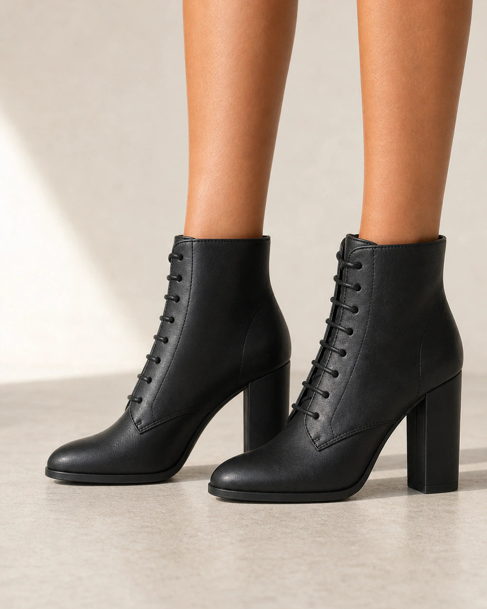 Women's black lace-up high-heel ankle boots, lateral profile.