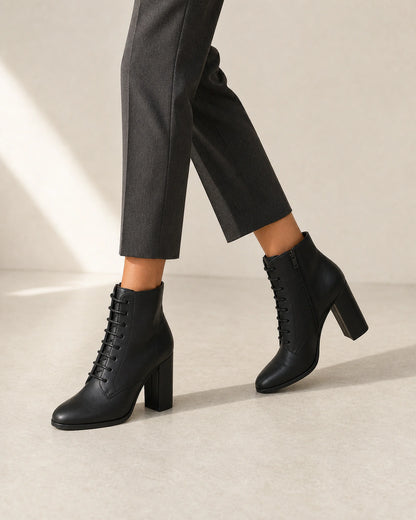 Women's black lace-up high-heel ankle boots, walking view.
