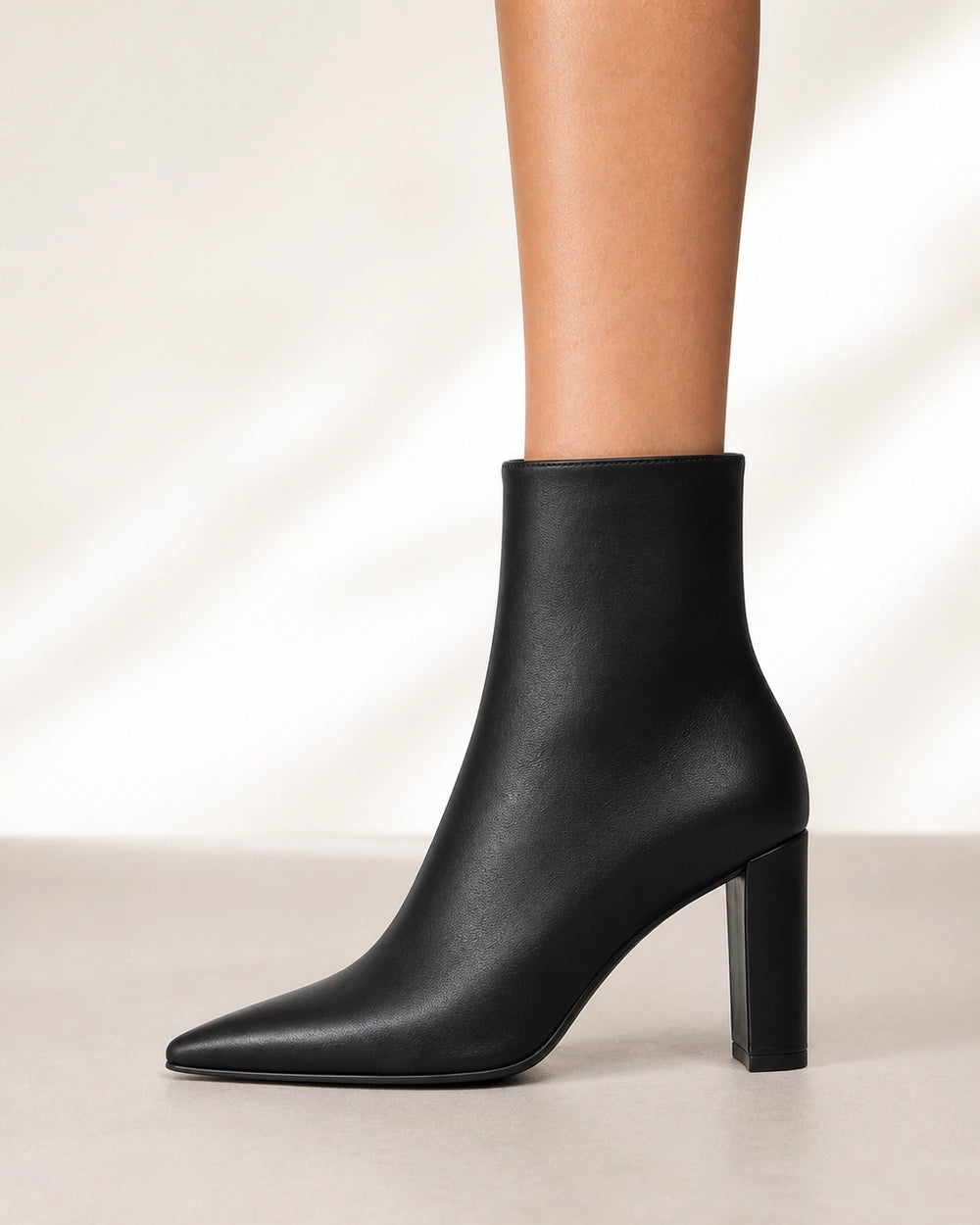Women's black pointed-toe high-heel ankle boots, lateral profile.