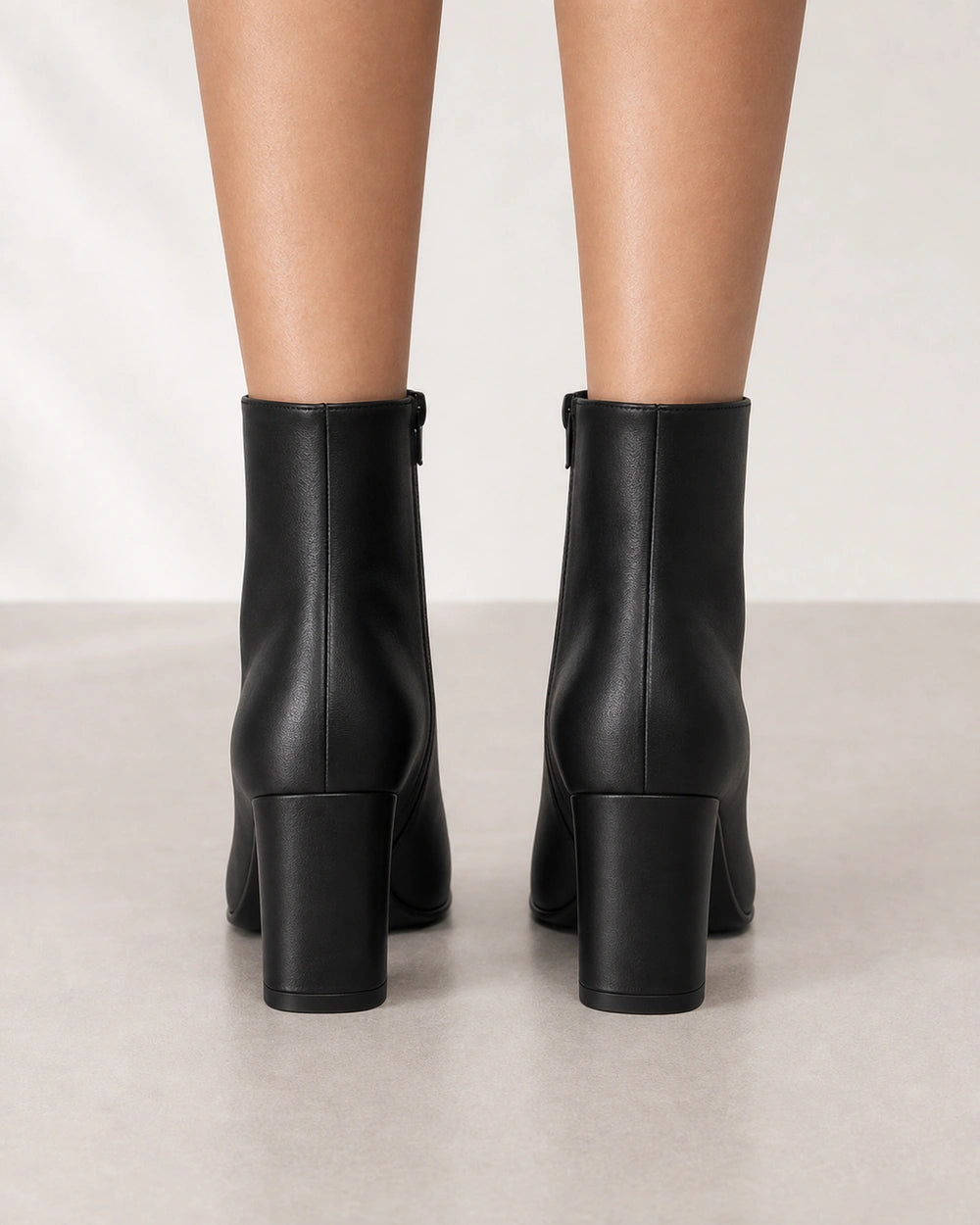 Women's black pointed-toe high-heel ankle boots, rear view.