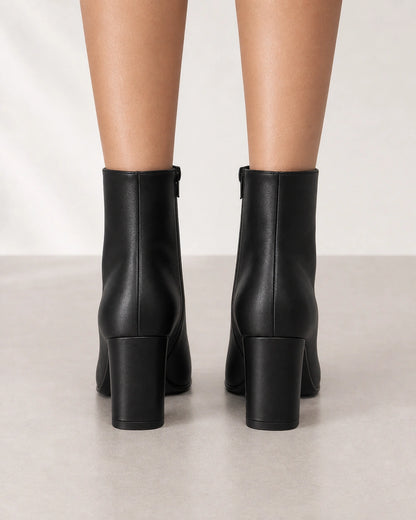 Women's black pointed-toe high-heel ankle boots, rear view.