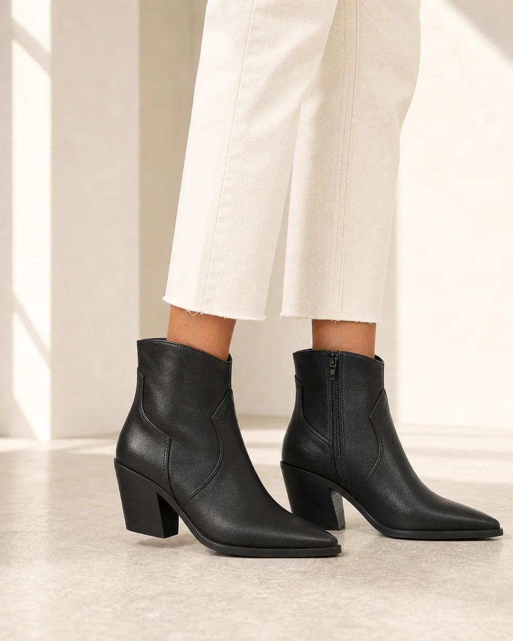 Women's black pointed western ankle boots, lateral profile.