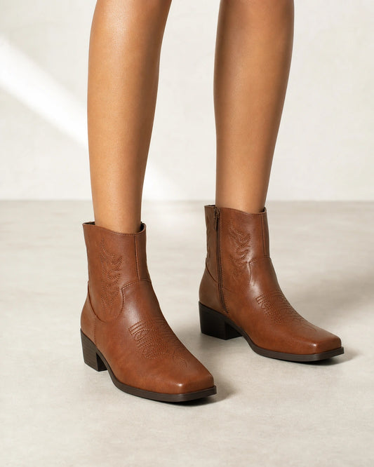 Women's brown square-toe western ankle boots, front three-quarter view.