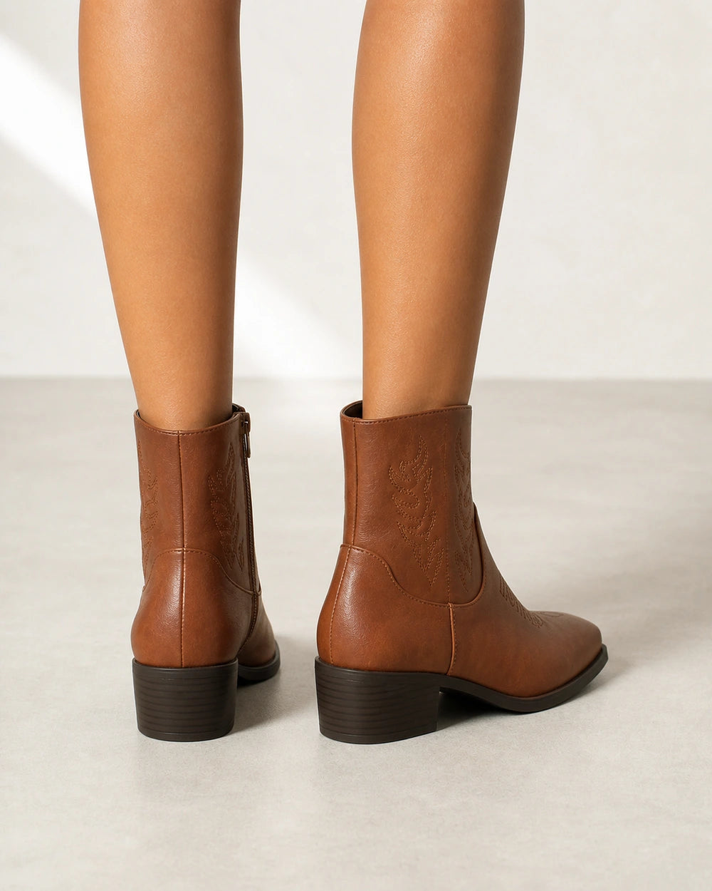Women's brown square-toe western ankle boots, rear view.