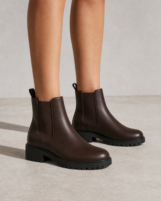 Women's chocolate brown lug-sole Chelsea boots, front three-quarter view.