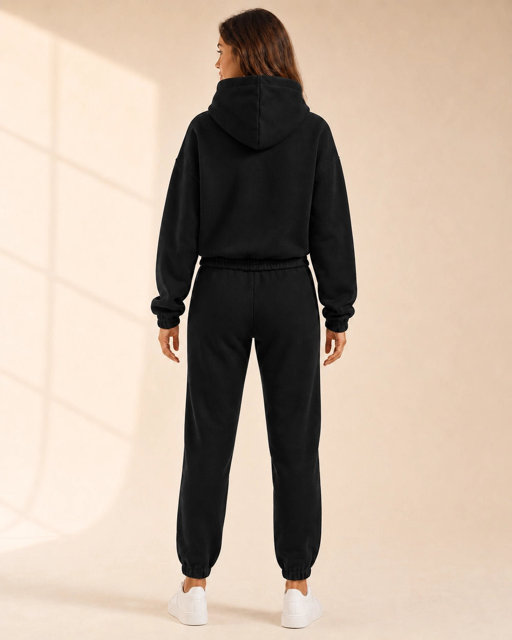 Women's black hooded two-piece jogger set, rear view.