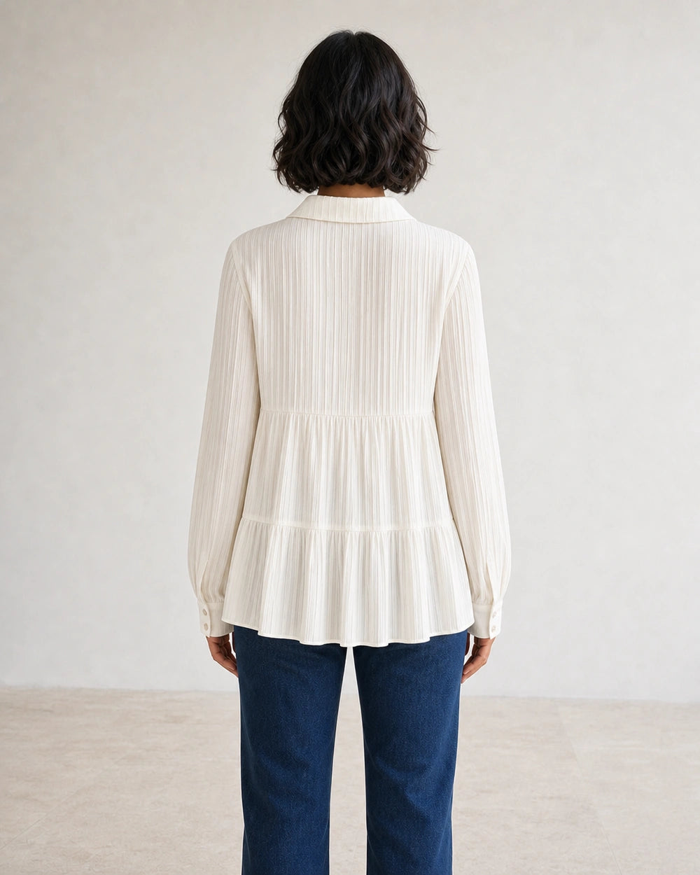 Women's milk-white pleated peplum shirt, rear fit view.