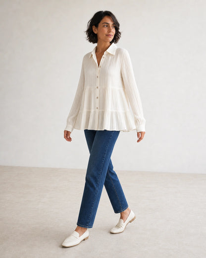 Women's milk-white pleated peplum shirt in a walking movement view.