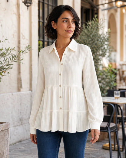 Women's milk-white pleated peplum shirt in an Italian café lifestyle setting.
