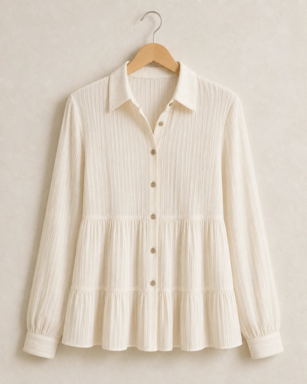 Milk-white pleated peplum shirt, product-only hanger view.