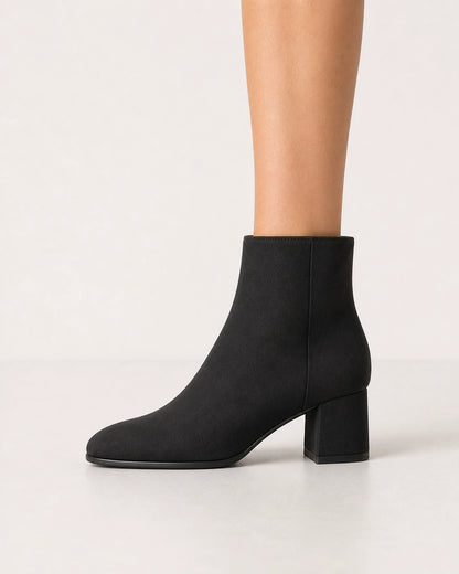 Women's minimalist black block-heel ankle boots, lateral profile.