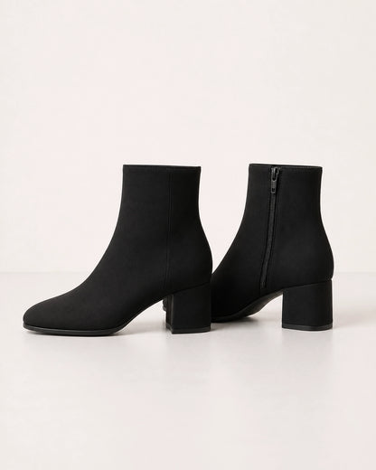 Women's minimalist black block-heel ankle boots, product-only view.
