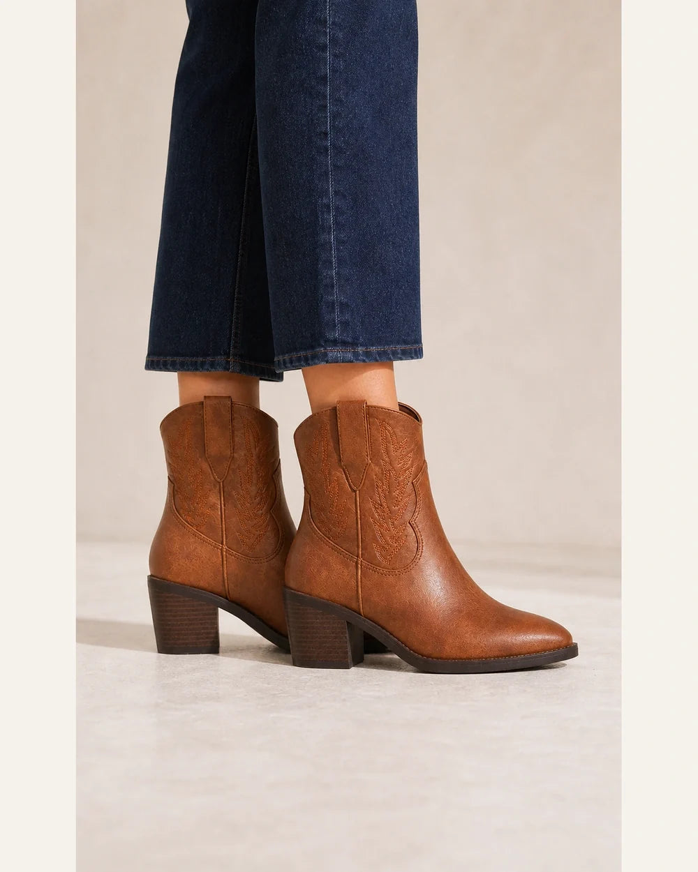 Vintage brown cowboy ankle boots, lateral profile without distortion.
